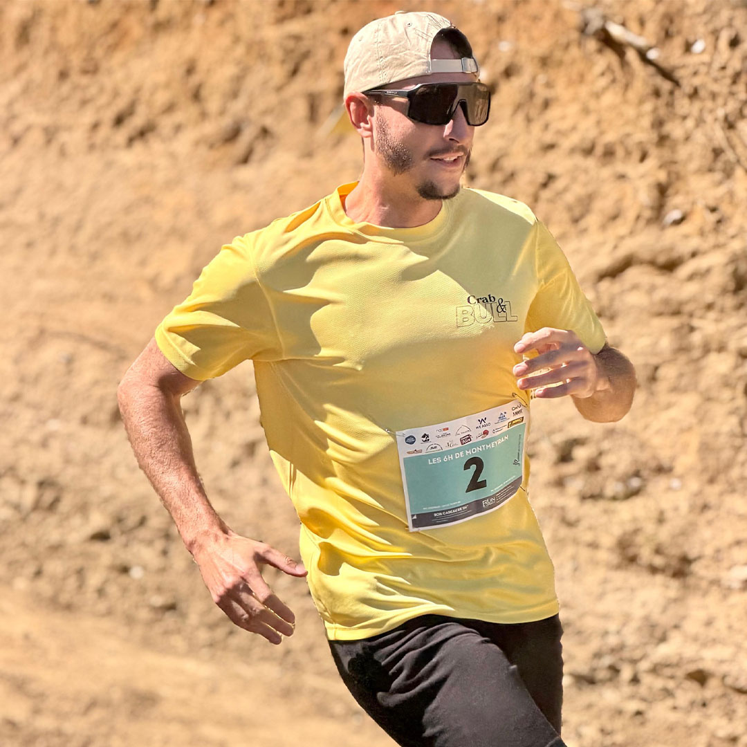 Un membre de Crab & Bull en course avec le t-shirt jaune et sa signature sur la poitrine